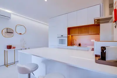 a white kitchen with a large white counter top at Valmangude - Collection design par Enjoyyourstay in Albufeira