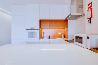 a kitchen with white cabinets and a sink at Valmangude - Collection design par Enjoyyourstay in Albufeira