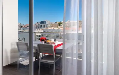 a table and chairs on a balcony with a view of a city at D_Loft Downtown in Albufeira