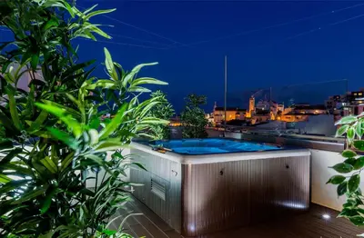 a jacuzzi tub on a balcony at night at D_Loft Downtown in Albufeira
