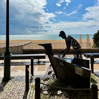 a statue of a bird sitting in a trash can near the beach at OldTownPool Albufeira in Albufeira