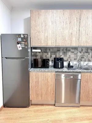a kitchen with a stainless steel refrigerator and wooden cabinets at StayBaixa Faro in Faro