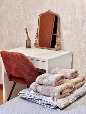 a desk with a mirror and a chair with towels at StayBaixa Faro in Faro