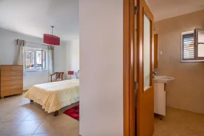a bedroom with a bed and a bathroom with a sink at Villa Ancora - Nex to the Beach - Parking - Swimming Pool - BY BEDZY in Albufeira
