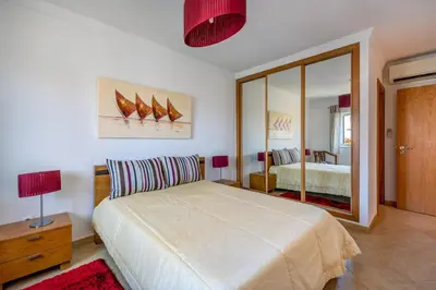 a bedroom with a large bed and a mirror at Villa Ancora - Nex to the Beach - Parking - Swimming Pool - BY BEDZY in Albufeira