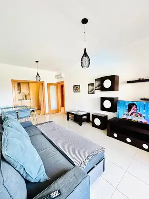 a living room with a couch and a flat screen tv at Albufeira Comfort Luxury Quinta Barracuda in Albufeira
