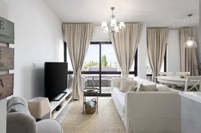 a living room with a white couch and a tv at Vilamoura Retreat - Sunset View by HD in Vilamoura