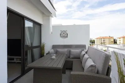 a patio with a couch and a table on a balcony at Vilamoura Retreat - Sunset View by HD in Vilamoura