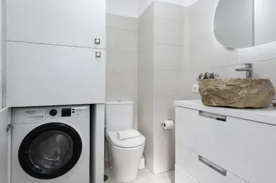 a white bathroom with a washing machine and a sink at Vilamoura Retreat - Sunset View by HD in Vilamoura