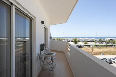 a balcony with a table and a view of the city at Espadarte - Sea view by HD in Quarteira