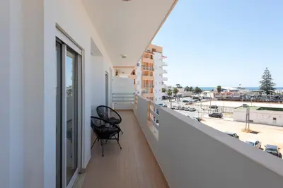 a balcony with two chairs and a view of a city at Espadarte - Sea view by HD in Quarteira
