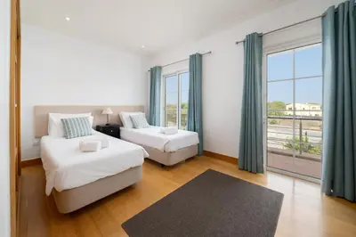 a bedroom with a bed and a couch and a window at Palmyra Apartments in Vilamoura in Vilamoura