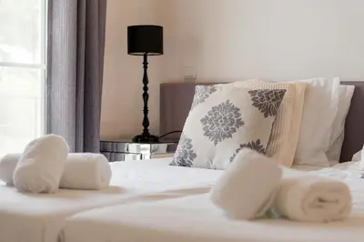a white bed with a pillow and towels on it at Palmyra Apartments in Vilamoura in Vilamoura