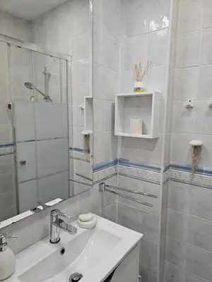a white bathroom with a sink and a mirror at Faro Heart House in Faro