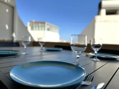 a table with a plate and wine glasses on it at Villa Terraza - Center Hideaway in Albufeira
