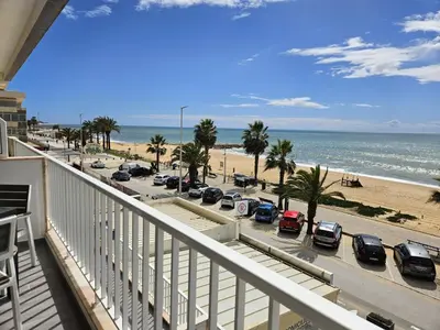 a balcony with a view of the beach and cars at Apartamento moderno na praia com varanda grande in Quarteira