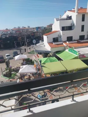 a view of a building with umbrellas and a tennis court at Albufeira Oura Apartment in Albufeira