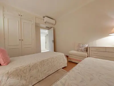 a small bedroom with two beds and a chair at Marina Mar Sunset by SAPvillas in Vilamoura