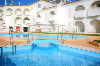 a pool in front of a building with a swimming pool at São Rafael 1 Bedroom with Pool in Albufeira