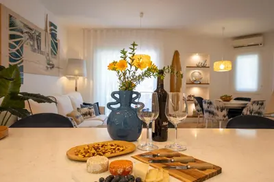 a table with a plate of cheese and wine glasses at Luxury Beach House Apartment - Golf & Tennis Court & Pool View in Albufeira