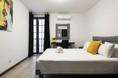 a white bedroom with a large bed with yellow pillows at Fonte Moura - With pool by HD in Vilamoura