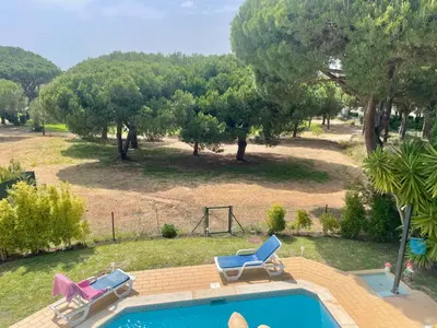a swimming pool with two lounge chairs and a park at Villa Maria in Vilamoura