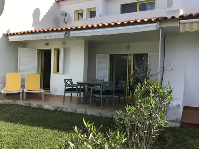 a patio with a table and chairs in front of a house at 2 Bedroom Townhouse, Vale de Parra in Guia