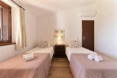 two twin beds in a room with white walls at Casa da Colina in Albufeira
