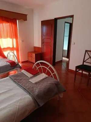 a bedroom with a bed with two chairs and a mirror at Villa Vacations Marie in Albufeira