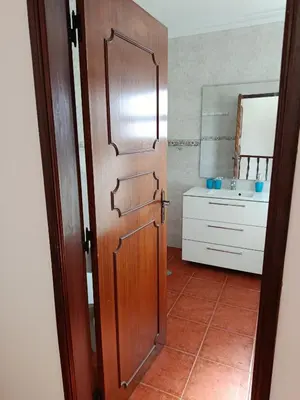 a bathroom with a wooden door and a sink at Villa Vacations Marie in Albufeira