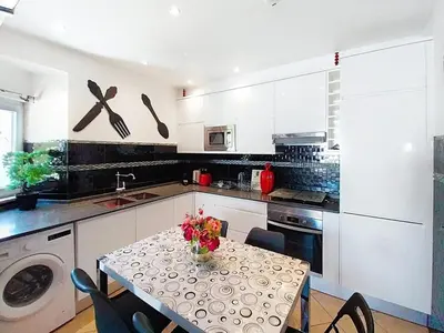 a kitchen with a table with a vase of flowers on it at Central View 990 meters from beach on foot in Albufeira