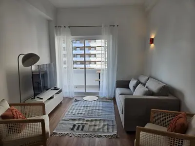 a living room with a couch and a television at Apartamento moderno com vista para o mar em Faro in Faro