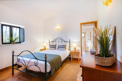 a bedroom with a bed and a dresser with a mirror at Quinta da Bisa - Casa das Pedrinhas in Algoz