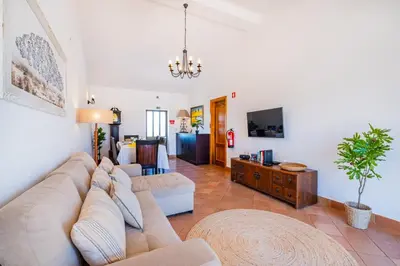 a living room with a couch and a tv at Quinta da Bisa - Casa das Pedrinhas in Algoz