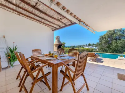 a dining room with a table and chairs on a patio at Villa Rosa by Interhome in Sesmarias