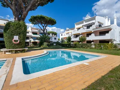 a villa with a swimming pool in front of a building at Apartment Brisa dos Pinheiros by Interhome in Vilamoura