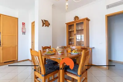 a dining room with a wooden table and chairs at #316 Flat New Town by Home Holidays in Albufeira