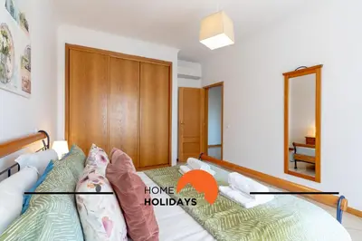 a bedroom with a bed and a mirror at #316 Flat New Town by Home Holidays in Albufeira