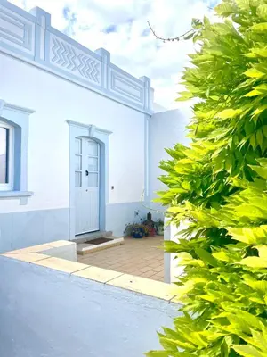 a white house with a door and a hedge at Toca das Manas in Roja- Pé