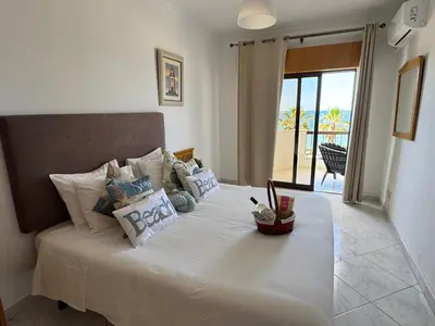 a bedroom with a bed with a view of the ocean at Adrimar - Beachfront Sea View 2BR Apartment in a prime location in Quarteira