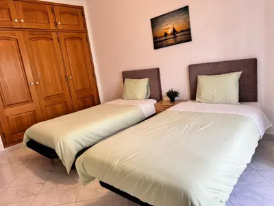 two beds sitting next to each other in a room at Adrimar - Beachfront Sea View 2BR Apartment in a prime location in Quarteira