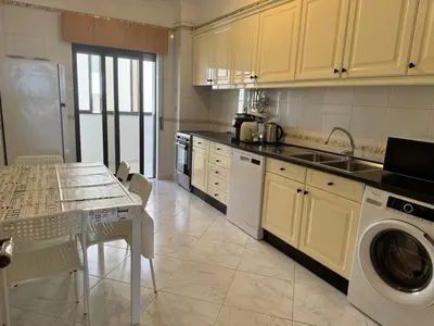 a kitchen with a table and a washing machine at Adrimar - Beachfront Sea View 2BR Apartment in a prime location in Quarteira