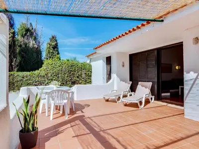 a patio with white chairs and a table at Volta da Vinha, 3bdr Private Vila in Vilamoura in Vilamoura
