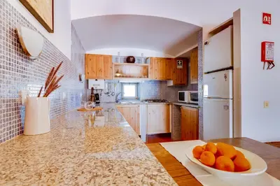a kitchen with a bowl of oranges on a counter at Volta da Vinha, 3bdr Private Vila in Vilamoura in Vilamoura