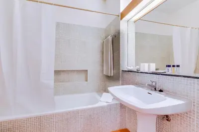 a white bathroom with a sink and a bath tub at Volta da Vinha, 3bdr Private Vila in Vilamoura in Vilamoura