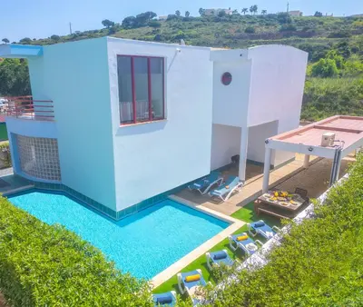 a pool with blue chairs and a house at Villa Marina by Algarve Vacation in Albufeira