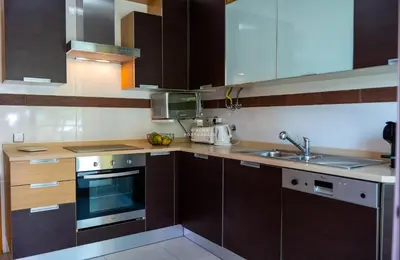 a kitchen with wooden cabinets and a sink at Apartamento Varandas do Mar in Albufeira