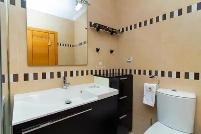 a bathroom with a sink and a toilet and a mirror at Apartamento Varandas do Mar in Albufeira