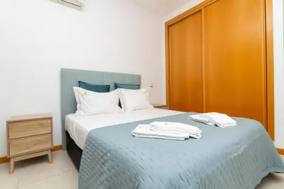 a bedroom with a bed with two towels on it at Apartamento Varandas do Mar in Albufeira