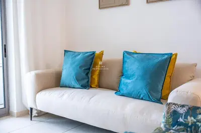 two blue pillows on a couch in a living room at Apartamento Varandas do Mar in Albufeira